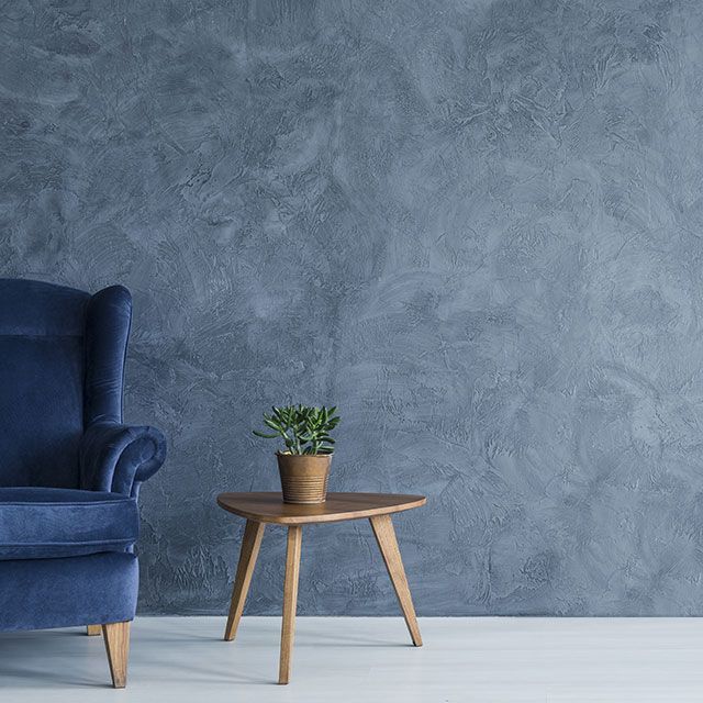 a blue chair sitting next to a table with a potted plant on it