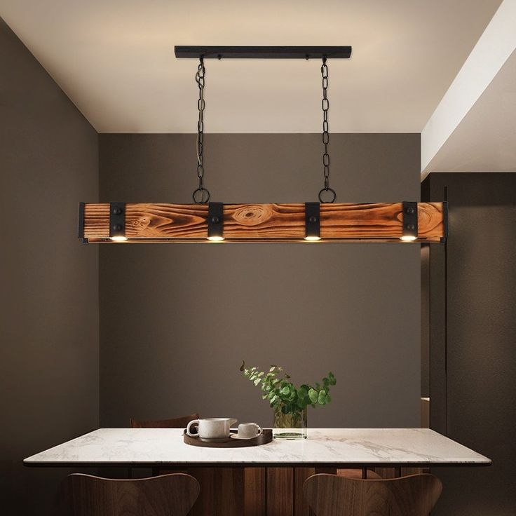 a dining room table with two chairs and a light fixture hanging from it's ceiling