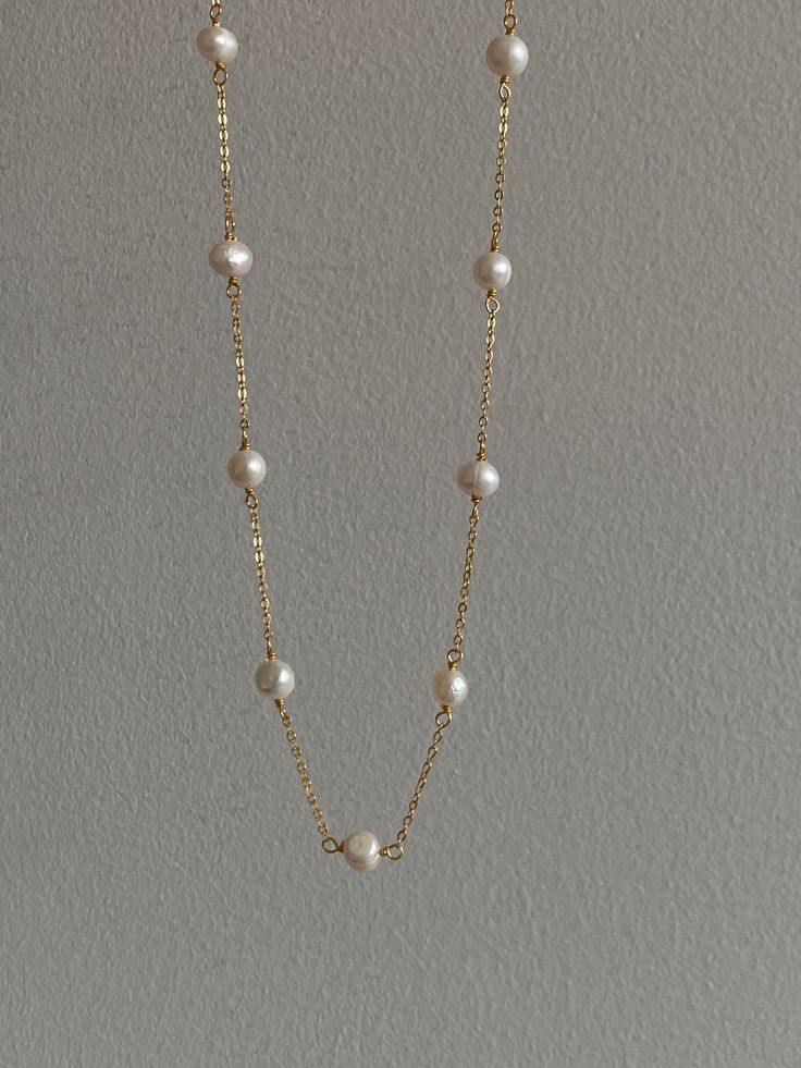 Introducing our Golden Freshwater Pearl Necklace, a harmonious blend of the classic elegance of a pearl necklace with the understated charm of a minimalist necklace. This piece is meticulously crafted from 925 sterling silver, bathed in a radiant layer of 18k gold, resulting in a beautiful gold necklace. It features thirteen evenly spaced natural freshwater pearls, each approximately 6-7mm in size, infusing a touch of sophistication into the modern gold chain necklace design. The standard length Pearl Necklace Simple, Beaded Pearl Necklace, Simple Pearl Necklace, Beautiful Gold Necklaces, Gold Necklace Simple, Pearls Necklace, Necklace Design, Necklace Simple, Necklace Dainty