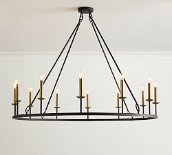 a chandelier hanging from the ceiling with lit candles on each candle holder in front of it