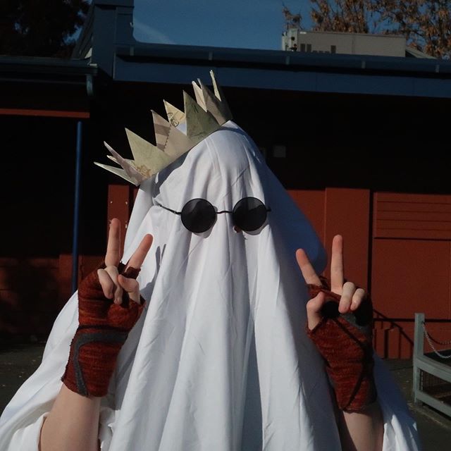 a person dressed in a ghost costume with two fingers up