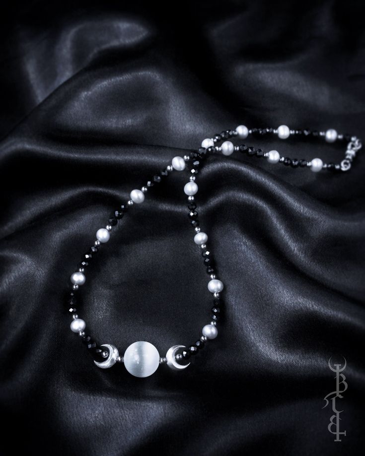 In honour of Artemis, Goddess of the wilds and Goddess of the moon. She who wears the crescent moon crown. An enchanting beaded strand featuring a Selenite sphere framed by crescent moons, and strung between black Onyx and silver freshwater pearls. This necklace depicts the Triple Goddess symbol,  the Selenite bead in the centre symbolising the full moon with a waxing and waning crescent on either side.  The crescent moon beads are produced in sterling silver and are uniquely textured by hand gi Bohemian Beaded Crescent Jewelry, Bohemian Crescent Beaded Jewelry, Festival Jewelry With Moon Charm And Round Beads, Mystical Adjustable Necklace With Round Beads, Adjustable Mystical Necklace With Round Beads, Bohemian Moon Phase Round Beaded Jewelry, Celestial Jewelry With Moon Charm And Round Beads, Celestial Round Beads Jewelry For Festival, Mystical Beaded Jewelry