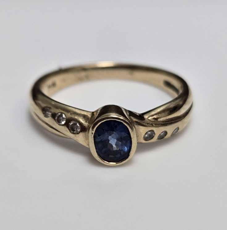 a gold ring with a blue sapphire and diamonds