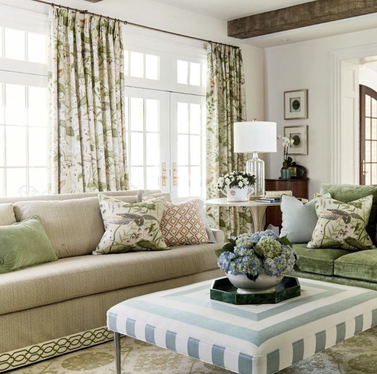 a living room filled with lots of furniture and pillows on top of a table in front of a window