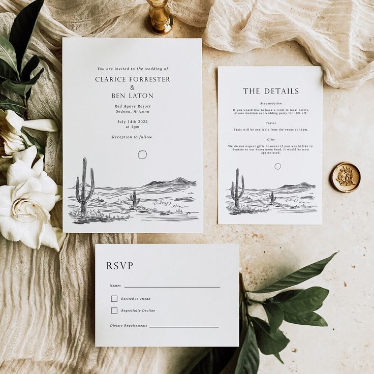 the wedding stationery is laid out on a table with flowers and greenery next to it