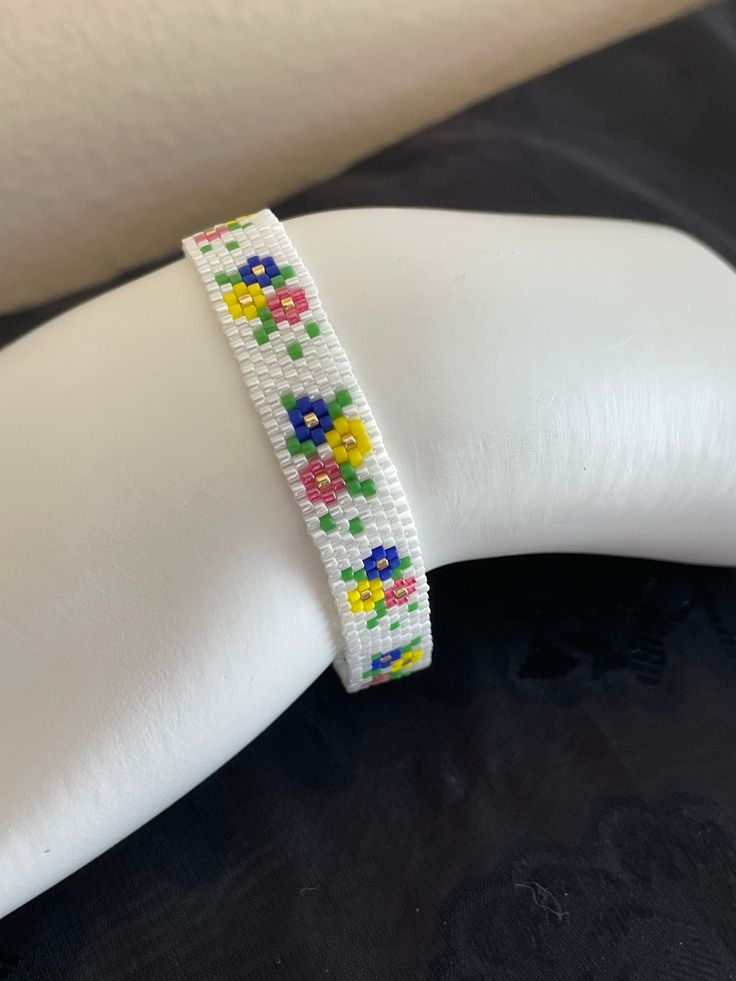 a white bracelet with colorful flowers on it