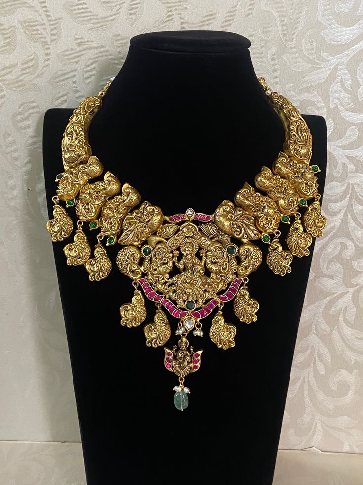 Antique Lakshmi Pendent Temple Necklace An antique Lakshmi temple necklace is a traditional piece of South Indian jewelry, often crafted in gold or gold-plated metal. The necklace typically features intricate designs inspired by temple architecture and Hindu mythology, particularly the goddess Lakshmi, who symbolizes wealth and prosperity. Luxury Formal Temple Necklace With Tilla Details, Luxury Handmade Elegant Temple Necklace, Luxury Engraved Temple Necklace For Ceremonial Occasions, Luxury Traditional Beaded Temple Necklace, Luxury Ceremonial Pendant Temple Necklace, Luxury Yellow Gold Temple Necklace For Rituals, Luxury Wedding Temple Necklace With Intricate Design, Traditional Brass Temple Necklace, Luxury, Festive Round Temple Necklace