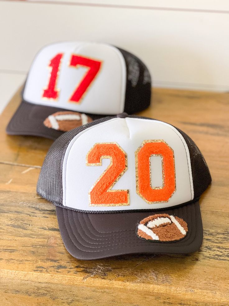 two hats with numbers on them sitting on top of a wooden table in front of a wall