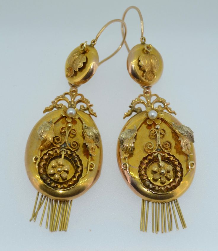 A lovely pair of Original Victorian-era earrings. These earrings date from the late 1800s. They are crafted from 14K Yellow and Rose Gold. The earrings are day and night, meaning you can adorn the ear with the button tops alone or add the massive body for a very dramatic look. These earrings instantly reminded me of lockets. The body is an oval shape with a gold fringe at the bottom. The fronts of the body are decorated with applied fine gold work in Rose Yellow and green gold. They are applied Pearl Fringe, Night Meaning, Victorian Earrings, Gold Fringe, 2024 Design, Art Nouveau Jewelry, Gold Work, Rose Yellow, Day Night