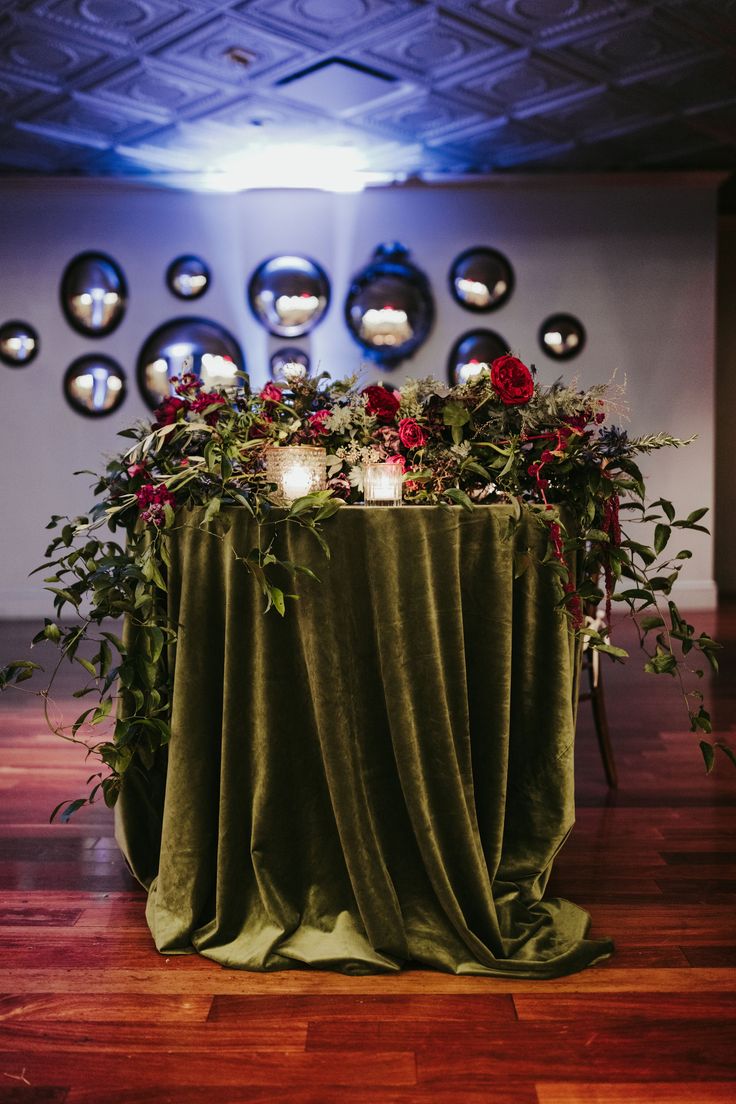 the table is covered with greenery and candles