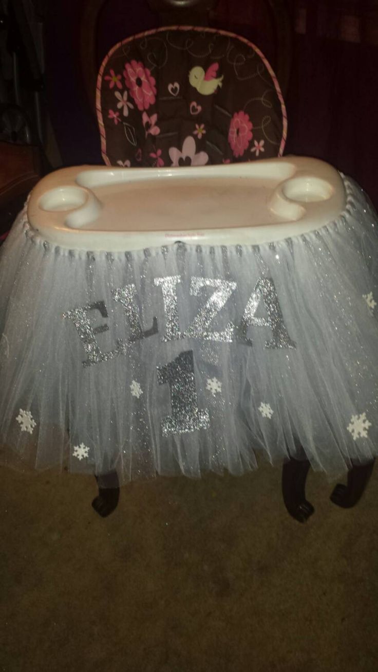 a baby's high chair that is decorated with silver and white sequins