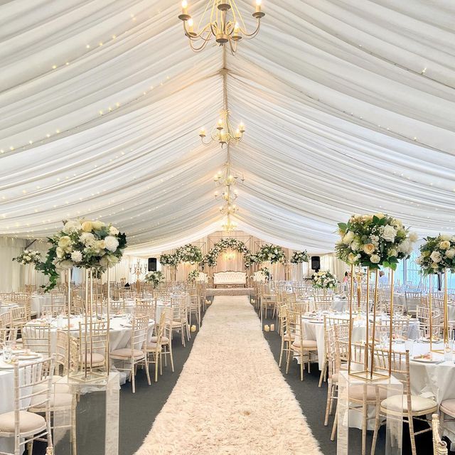 the inside of a white tent with tables and chairs set up for a wedding reception