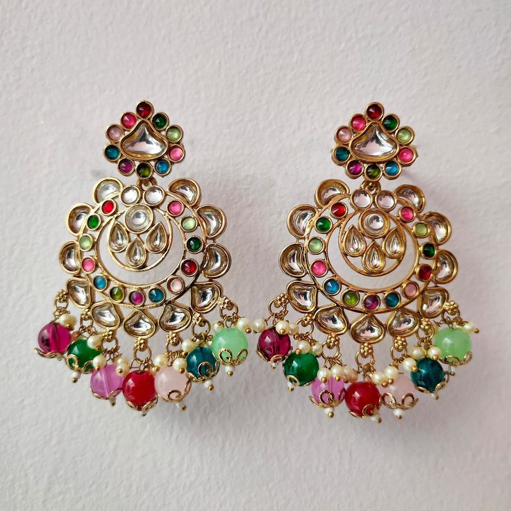 Experience a burst of vibrant elegance with our Multi-Color Beaded Indian Earrings, a dazzling Kundan Chandbali Set perfect for weddings and festive occasions. These earrings are a celebration of cultural fusion, combining traditional Indian and Pakistani elements in a harmonious design. The intricate beading and Kundan detailing add a touch of opulence, making them an ideal choice for special events. Elevate your style and embrace the richness of Indian and Pakistani wedding jewelry with these stunning earrings that effortlessly capture the essence of celebration and timeless beauty. Materials: Brass, Pearl, Kundan & Rhine Stone ❋❋ Shipping Methods ❋❋ Standard Delivery - Take up to 8-14 business days (Worldwide). ❋❋ Please be aware that the colors, shades, and texture shown may exhibit mi Festive Fusion Dangling Beads Earrings, Festive Fusion Danglers With Dangling Beads, Festive Dangling Beads Earrings For Celebration, Festive Beaded Drop Earrings For Celebration, Festive Drop Beaded Earrings For Celebrations, Festive Celebration Earrings With Dangling Beads, Celebration Chandbali Beaded Earrings, Celebration Beaded Chandbali Earrings, Beaded Chandbali Earrings For Celebration