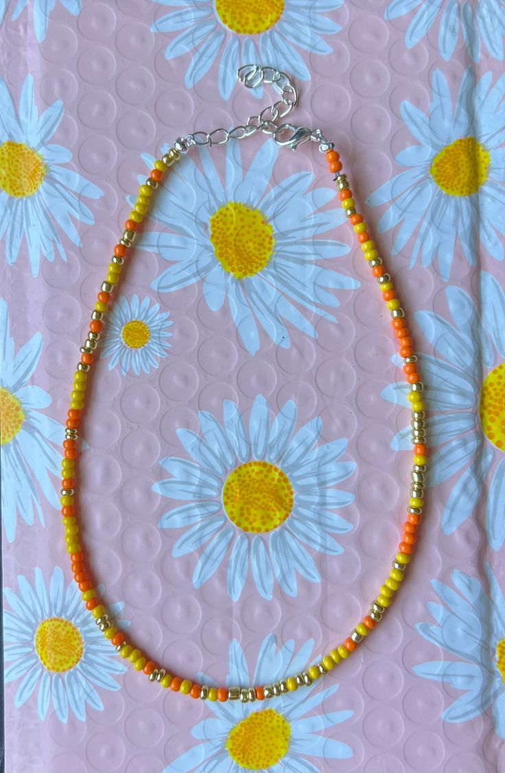 This is a sunrise colored necklace worn around the neck Tiny Yellow Beads For Summer, Yellow Round Bead Necklaces For Summer, Yellow Round Beads Necklace For Summer, Summer Yellow Beaded Necklaces With Large Beads, Yellow Beaded Necklaces With Large Beads For Summer, Yellow Beaded Chain Necklaces For Summer, Yellow Necklaces With Colorful Beads For Summer, Yellow Beaded Necklace For Summer Gifts, Adjustable Yellow Single Strand Beaded Necklaces