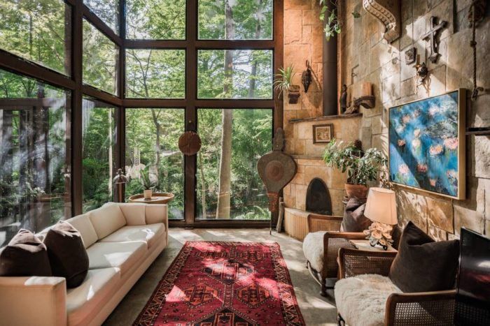 a living room filled with lots of furniture and large windows above the floor to ceiling windows