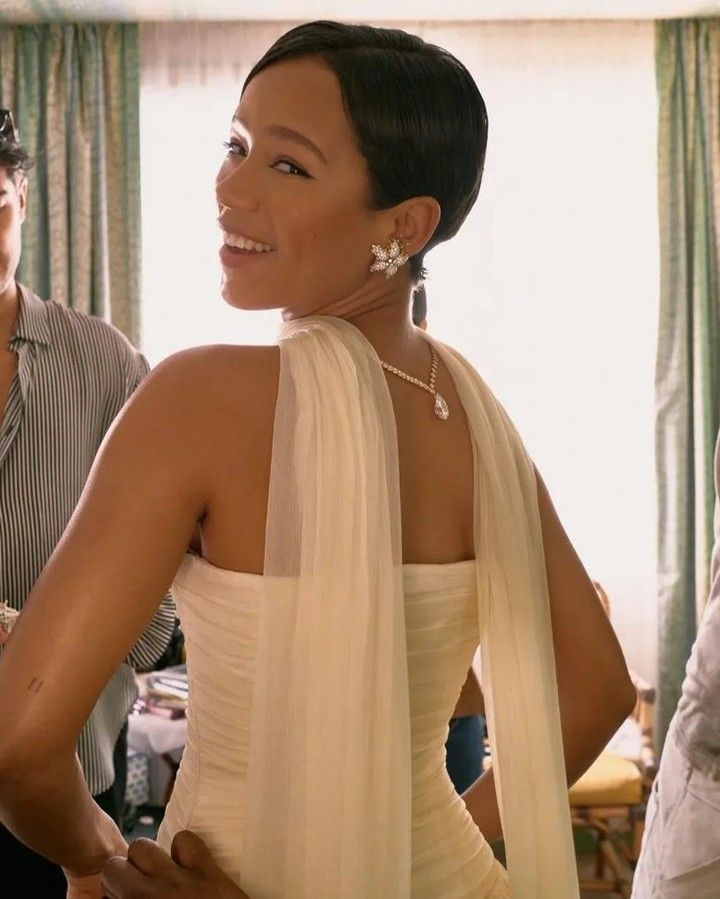 a woman in a white dress standing next to two men