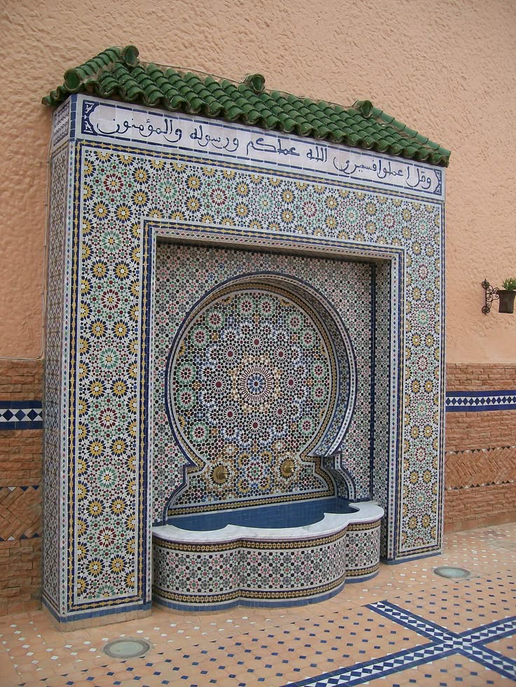 an intricately designed fountain in the middle of a tiled area with blue and white tiles