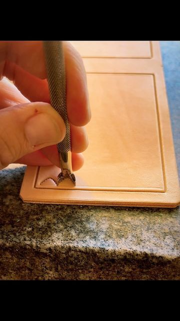 a person is holding a small metal object in their hand while they are working on something