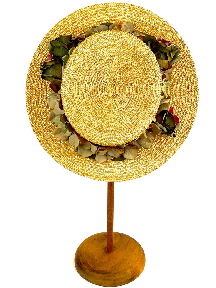 Romantic and elegant vintage style boater straw hat adorned with a composition of quality fabric flowers in shades of green and purple, attached to a 50 millimeter grosgrain ribbon. Made with 8/9 millimeters natural straw braid. Measurements in centimeters are 34 x 32. Crown height 9. Brim length 7. These measurements may have some slight variation depending on the size of the hat. For its elaboration we only use very good quality and resistant straw braids. In our workshop in the Pyrenees we se Vintage Hats For Kentucky Derby And Country Events, Handmade Vintage Hat Bands For Kentucky Derby, Vintage Adjustable Hat Bands For Vacation, Vintage Short Brim Mini Hats For Country Events, Vintage Mini Hat With Short Brim For Country Events, Vintage Wide Brim Mini Hat For Country Events, Gold Mini Hats For Beach And Spring, Handmade Vintage Top Hat For Country Events, Handmade Vintage Hat Bands