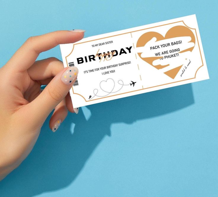 a person holding up a birthday ticket on a blue background