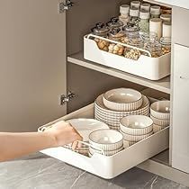 a person reaching for dishes in a kitchen drawer