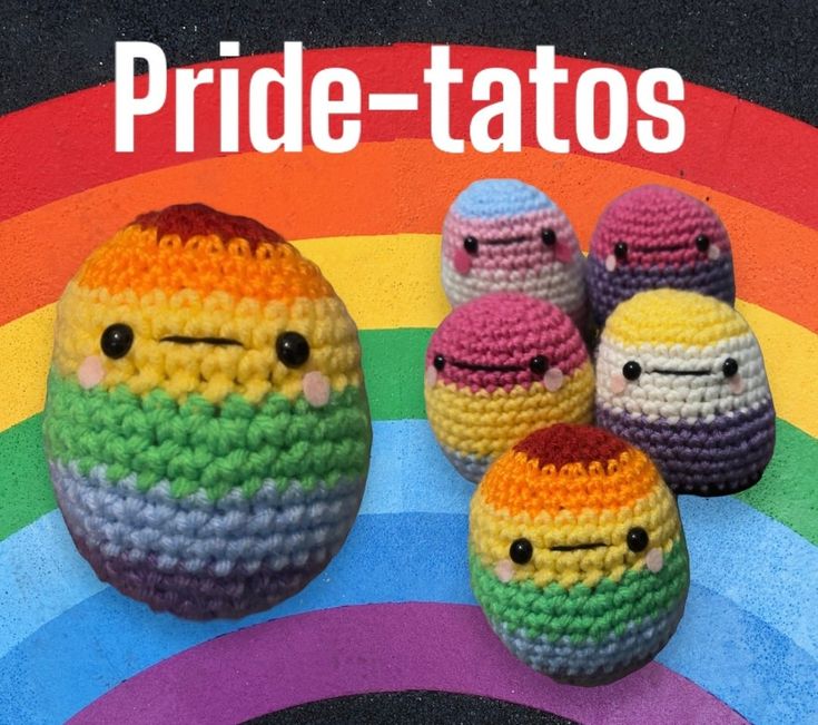 three crocheted eggs sitting next to each other in front of a rainbow colored background