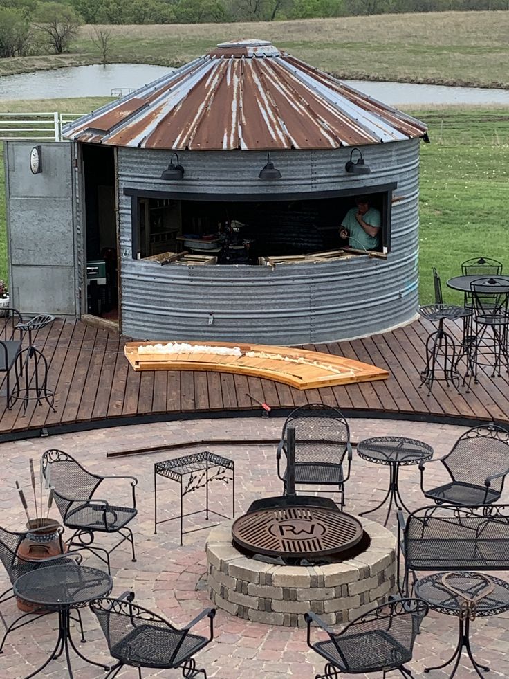 an outdoor bbq with chairs and tables around it