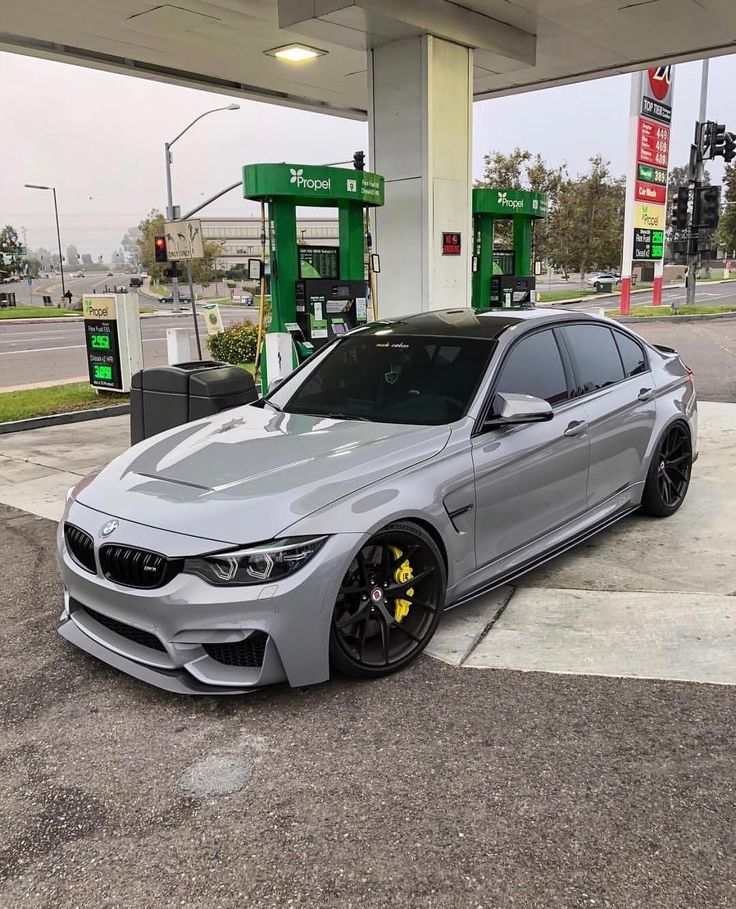 a silver car parked in front of a gas station