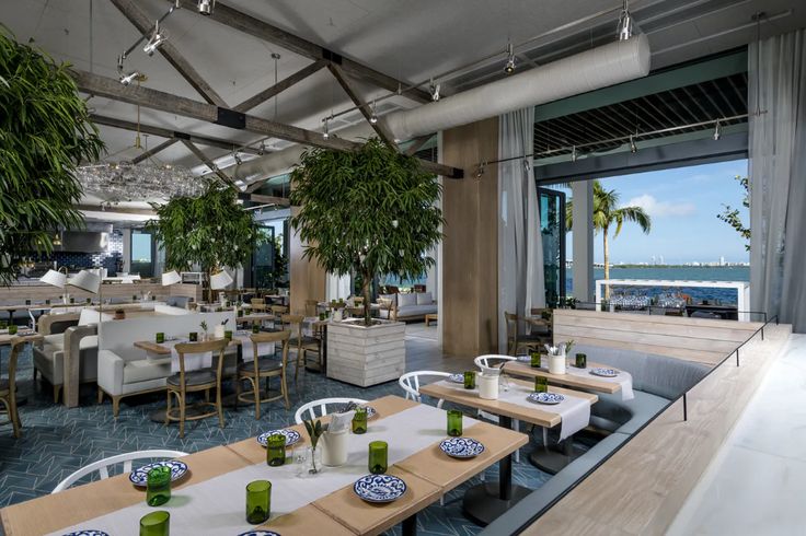 a restaurant with tables and chairs overlooking the ocean