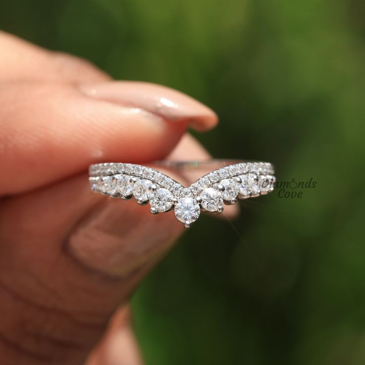 a person holding a diamond ring in their hand