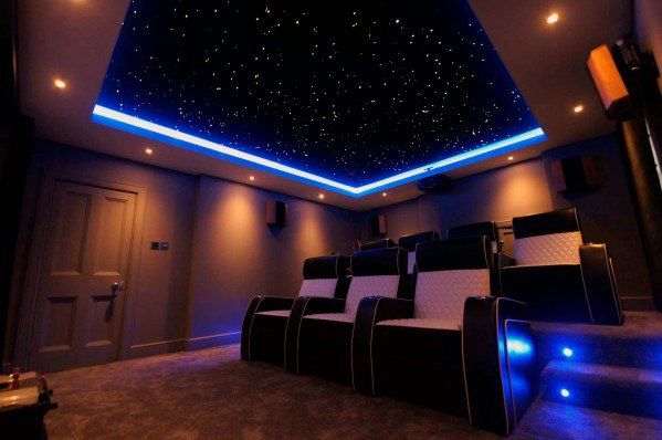 a home theater with blue lights and black seats