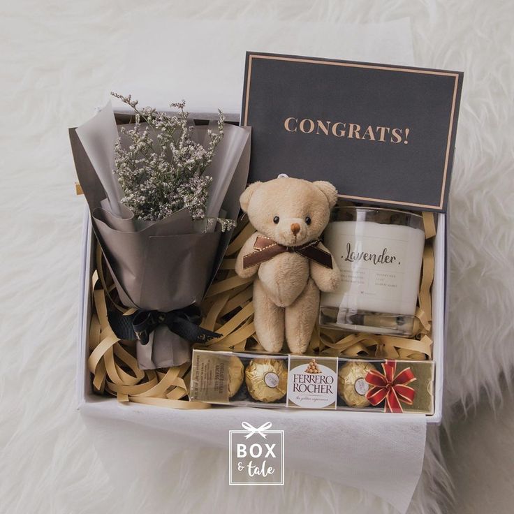 a teddy bear and some chocolates in a box with congratulations written on the side