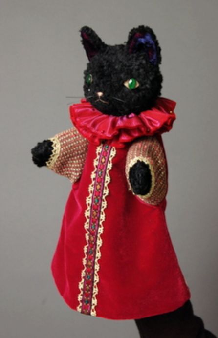 a black cat in a red dress with green eyes