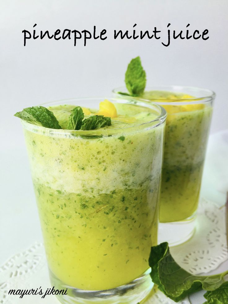 two glasses filled with pineapple mint juice on top of a white doily and green leaves