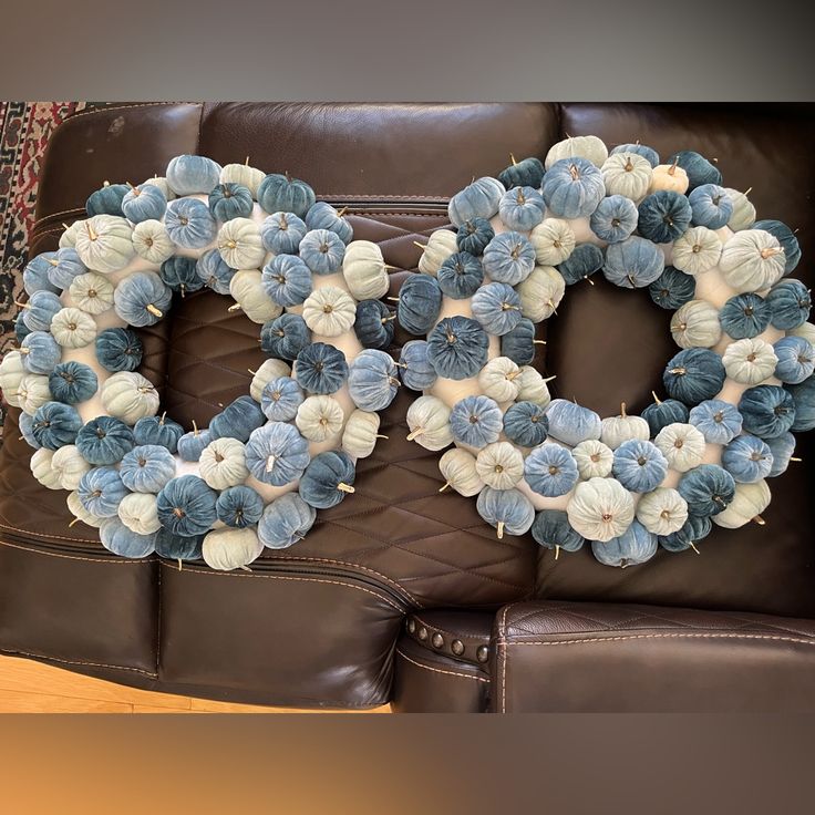 a decorative wreath sitting on top of a brown couch