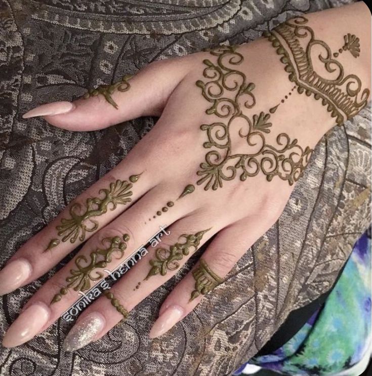 a woman's hand with henna tattoos on it