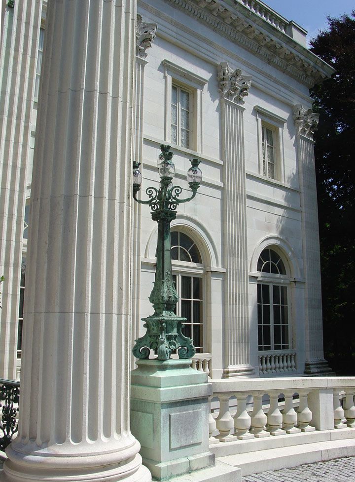 a tall white building with columns and a street light in front of it's entrance