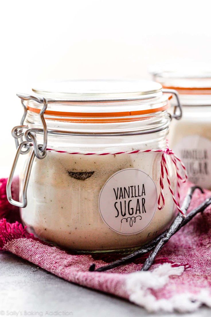 two jars filled with vanilla sugar sitting on top of a pink towel next to each other