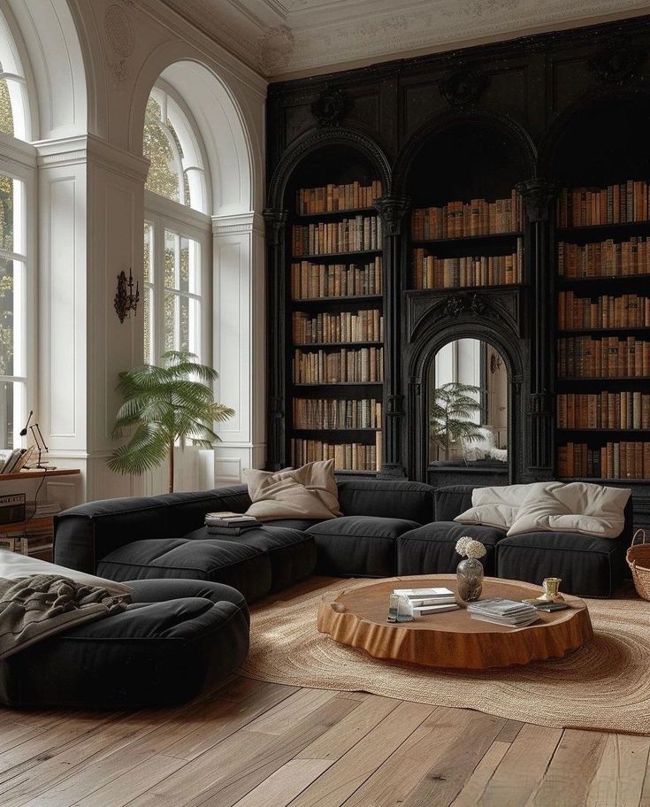 a living room filled with lots of furniture and bookshelves