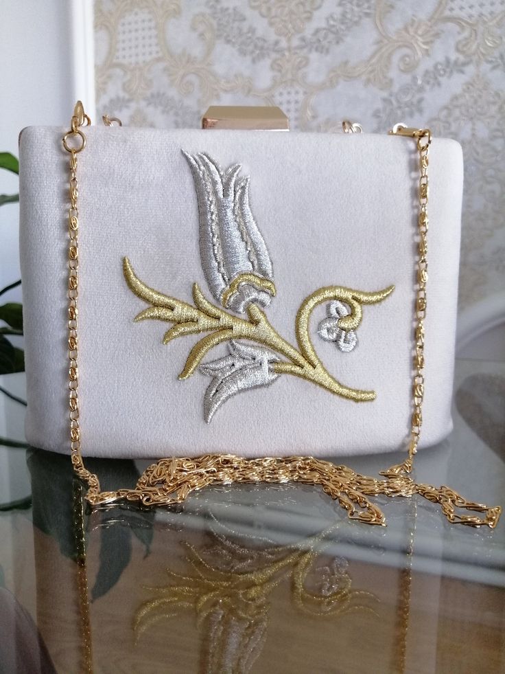 Complementing your elegance on your special days, our bags are embroidered with glitter thread on a cream velvet fabric, the inner lining is suede, the metal parts and chain are gold, our completely handcrafted bags will be yours only, they are unique in production. Luxury Bags With Intricate Embroidery For Gift, Handmade Cream Bag For Events, Handmade Cream Bags For Events, Silver Embroidered Bags As Gift, Silver Embroidered Bag For Gift, Gold Embroidered Evening Bag For Gift, Silver Embroidered Bags Suitable For Gifts, Handmade Cream Evening Bag As Gift, Handmade Cream Evening Bag For Gift