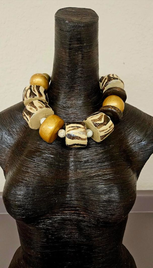 This was another piece that I thoroughly enjoyed creating! I was inspired by both Zebra's and Africa! The components include huge hand sculpted beads, magnesite rounds, wood, pave sequin beads, rhinestone rondelles, shiny gold tone metal beads, orange translucent rounds and gold tone metal crimps. This is another very lightweight piece which measures a non-adjustable 22" and closes with a tiny gold tone lobster claw clasp. These beads are light enough to float in water so they will not cause any Luxury Gold Necklace With Wooden Beads, Luxury Gold Beaded Statement Necklace, Luxury Traditional Jewelry With Wooden Beads, Luxury Ceremonial Necklaces With Large Beads, Luxury Gold Beaded Round Necklaces, Luxury Hand-strung Brown Beaded Necklaces, Luxury Brown Hand-strung Beaded Necklaces, Luxury Statement Gold Beads, Rocker Chic Accessories