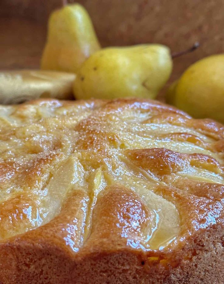 a close up of a cake with pears and bananas in the background