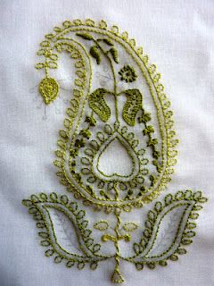 an embroidered paisley design on a white shirt with gold threadwork and sequins