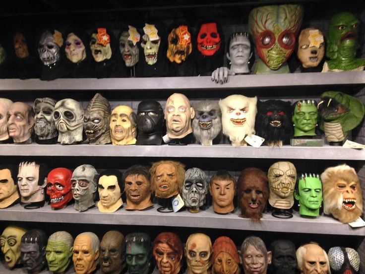 many different colored masks are on shelves in a room with no one wearing them yet