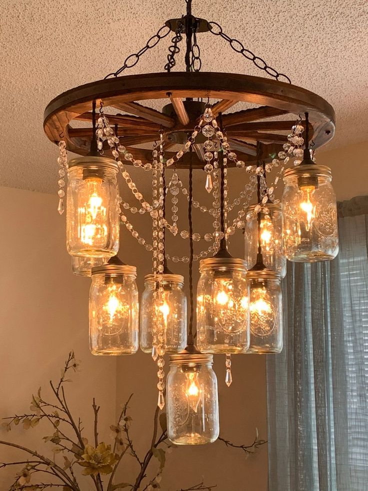 mason jar chandelier with lights hanging from it's centerpiece in a living room