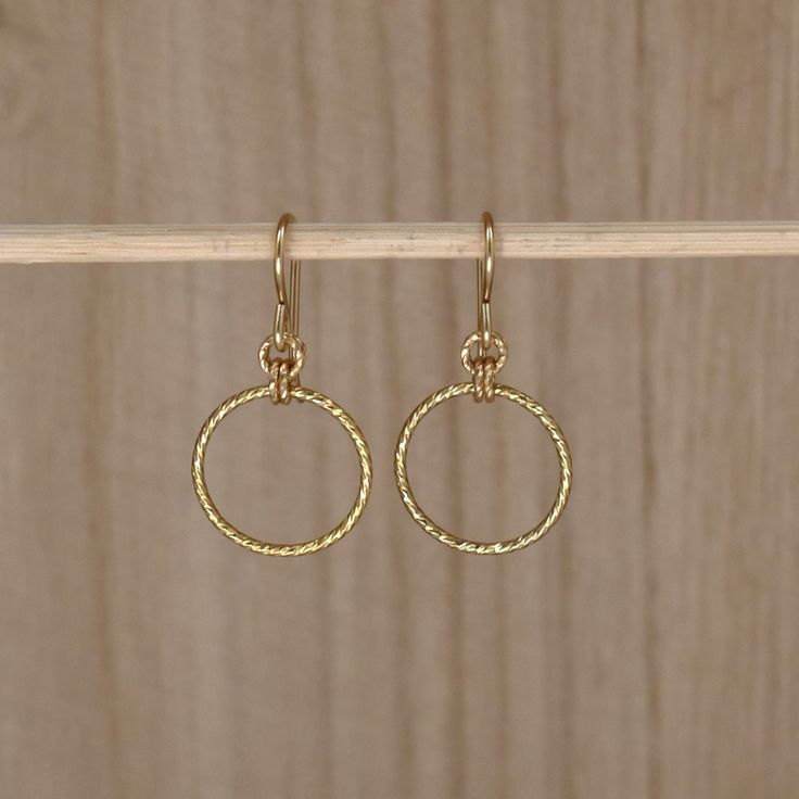 Gold Circle Drop Earrings. Simple Gold Dangle Earrings. Materials: 14Kt Gold Filled Crafted from textured gold wire, these earrings give off a charming sparkle. Simple and elegant, yet striking, they complement every outfit and make a fantastic gift. The earrings measure 15mm across and 29mm long (7/16 inch X 1 & 1/8 inch). What is gold-filled? Gold-filled jewelry contains almost 100 times more gold than gold-plated jewelry. It can be worn by people with sensitive skin without allergic reaction. Get the look and quality of solid gold at a fraction of the price. Browse my shop: ALLDANAE.etsy.com Dainty Recycled Gold Round Hoop Earrings, Dainty Recycled Gold Hoop Earrings, Recycled Gold Hoop Earrings For Gift, Delicate Small Hoop Yellow Gold Earrings, Hypoallergenic Round Earrings In Recycled Gold, Yellow Gold Hypoallergenic Dangle Hoop Earrings, Dainty Recycled Gold Earrings, Hypoallergenic Yellow Gold Dangle Hoop Earrings, Dainty Yellow Gold Dangle Hoop Earrings