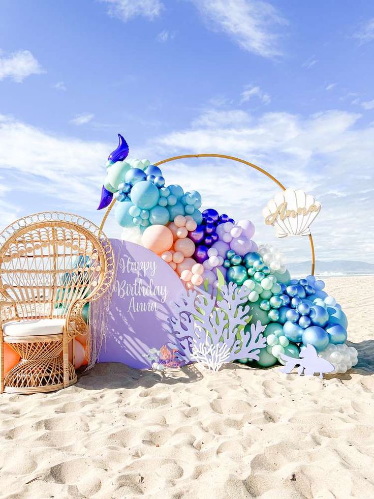 an ocean themed birthday party on the beach with balloons and decorations in pastel colors