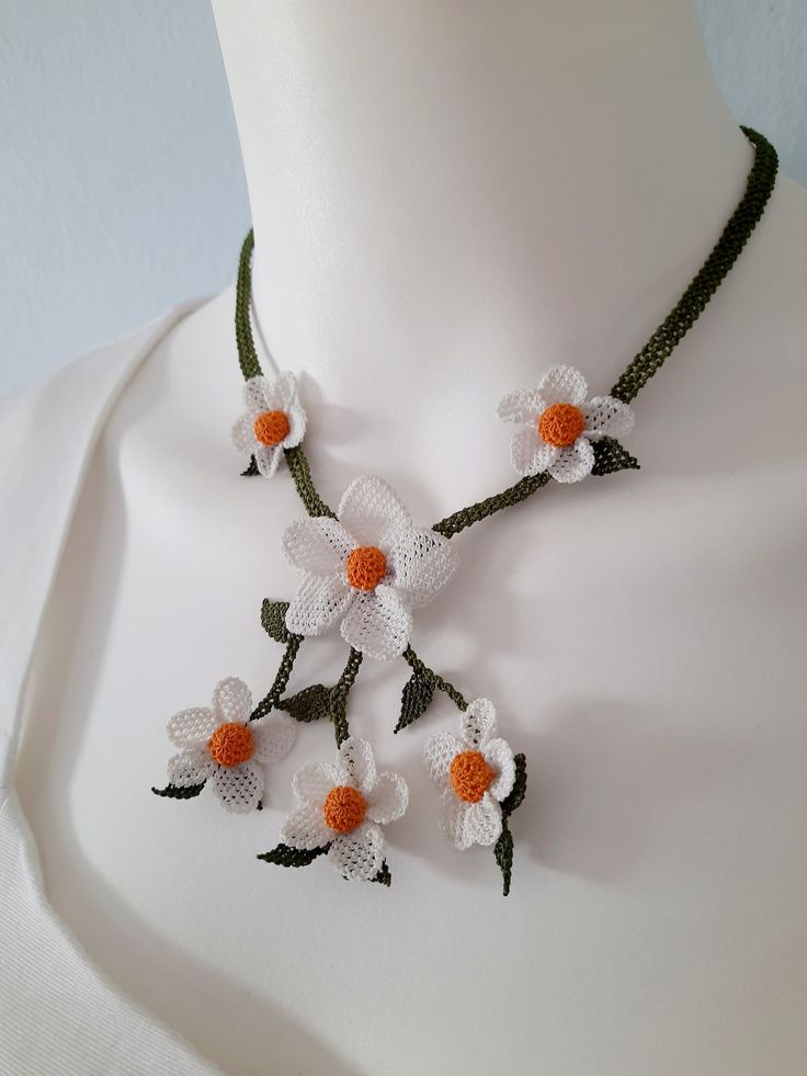 a white and orange flower necklace on a mannequin