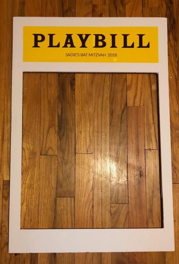 a wooden floor with a sign that says playbill on the bottom and yellow lettering above it