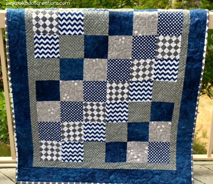 a blue and white quilt hanging from a rail